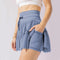 Mini-kjol med hög midja och inbyggda shorts, eleganta veck – perfekt för hösten